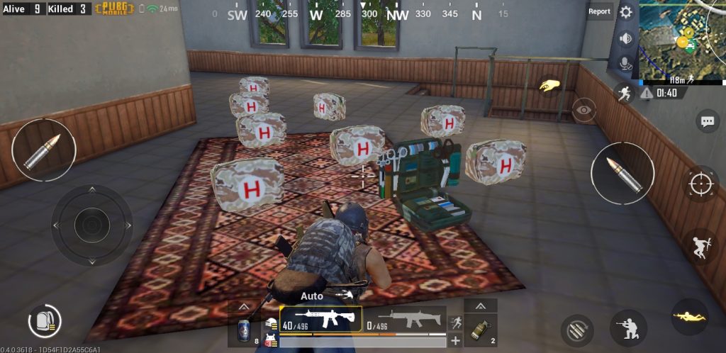 A scene in the battle royale game Pubg with nine mobile first aid kits scattered on the ground. There a carpet with the gamer's avatar helping another, a first aid kit that is opened to show the content such as scissors and bandages.