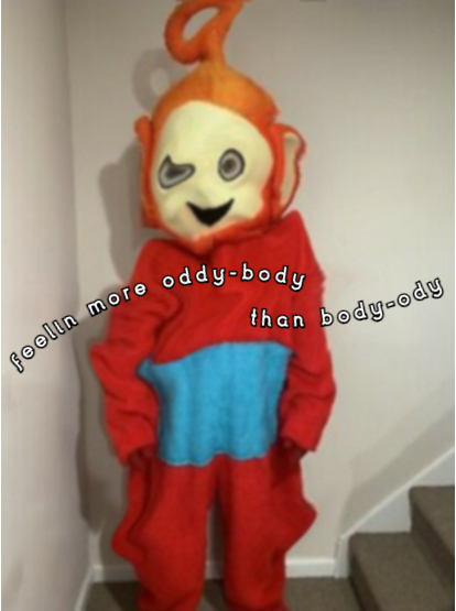 Someone wearing an unofficial teletubbies costume of the character Po, who is a large round red alien looking type creature with big ears and a circular antennae coming out the top of it's head and a blue square on it's tummy. They are standing at the bottom of a set of stairs in a white hallway. The costume is saggy and mishapen and the face is slightly menacing with wide eyes and a smile. The image has been edited to accentuate the sagginess with a slight swirling all over the costume. White text with a black background in two arches says 'feelin more oddy-body than body-ody'