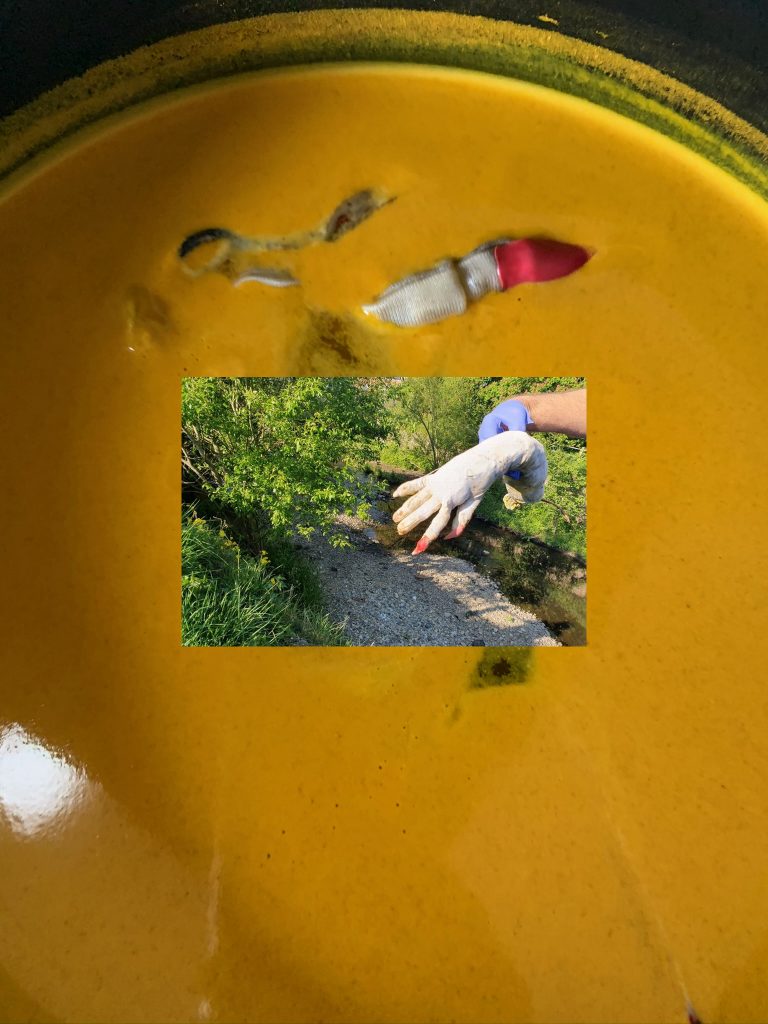 .. melted red plastic fingernail on  white hand in boiling put of tumeric on cheap stove in Kitchen in Birmingham, alongside the River Cole. Inset image:  an image of a large police-hand covered tight in sick-blue gloves, which the police wear when they are touching (t8n-time:2s)[[bodies->The Body]] or objects without consent. The rubbered-de-oxiganted-blue police hand holds a dirty white arm, with long read nails; dripping water. The red nails bleed on to fingers. The image is from (link: "this news article")[(goto-url: 'https://www.birminghammail.co.uk/news/midlands-news/hand-arm-found-river-cole-18211227')].