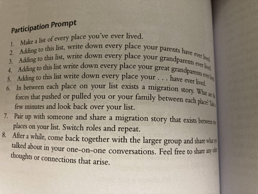 Photograph of text in book which reads:

Participation Prompt
1. Make a list of every place you've ever lived.
2. Adding to this list, write down every place your parents have ever lived.
3. Adding to this list, write down every place your grandparents ever lived.
4. Adding to this list write down every place your great grandparents ever lived.
5. Adding to this list write down every place your...have ever lived.
6. In between each pace on your list exists a migration story. What are the forces that pushed or pulled you or your family between each place? Take a few minutes and look back over your list.
7. Pair up with someone and share a migration story that exists between two places on your list. Switch roles and repeat.
8. After a while, come back together with the larger group and share with you talked about in your one-on-one conversations. Feel free to share any other thoughts or connections that arise.