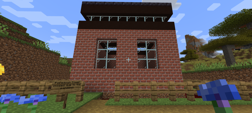 Screenshot of the Foredown Tower I created in Minecraft a brick square structure with two large portrait windows and a black roof with further windows going around the edge. 