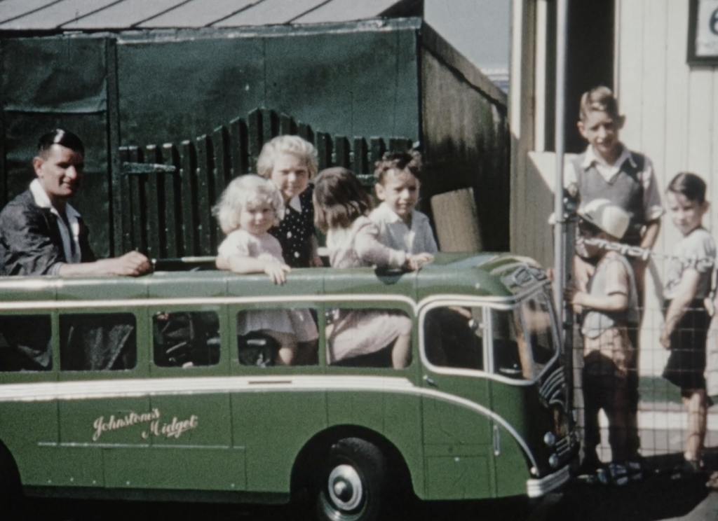 small children sitting in a model green toy bus