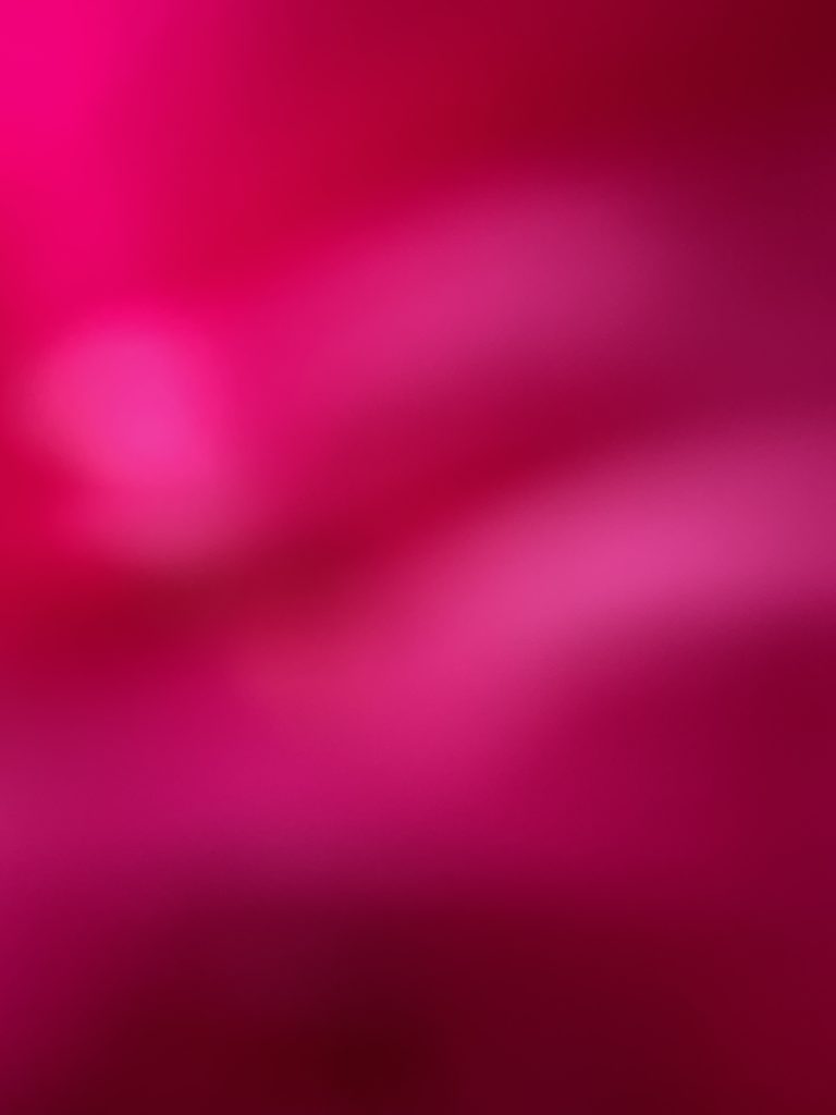 A digital photograph (portrait, colour), of what looks like an abstract image in shades of bright pink, fuschia, deep reds and burgundy. It looks like some kind of far off star nebulas, and it also looks like a an image caught on an iphone of the inside of someone's pocket; deep colours in soft crumpled blurring centres, bright light spots across the image. 