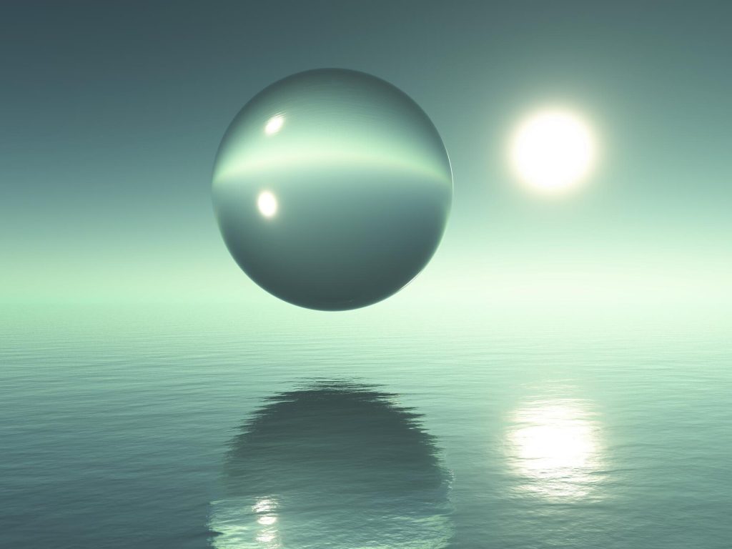 A reflective sphere floats above a calm, green body of water with the sun shining in the background and reflections visible on the surface.
